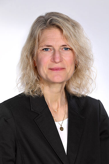 Frau in Anzug, professionelles Porträt.