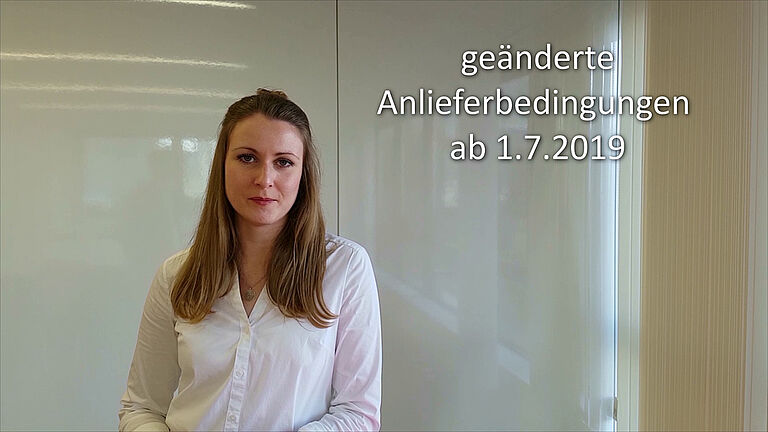 Frau in weißem Hemd spricht in einem professionellen Setting.