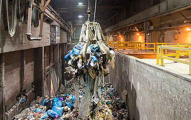 Abfallförderband transportiert gemischtes Material durch eine Verarbeitungsanlage.