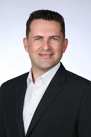 Professioneller Mann im Anzug, lächelnd, für ein Porträt.