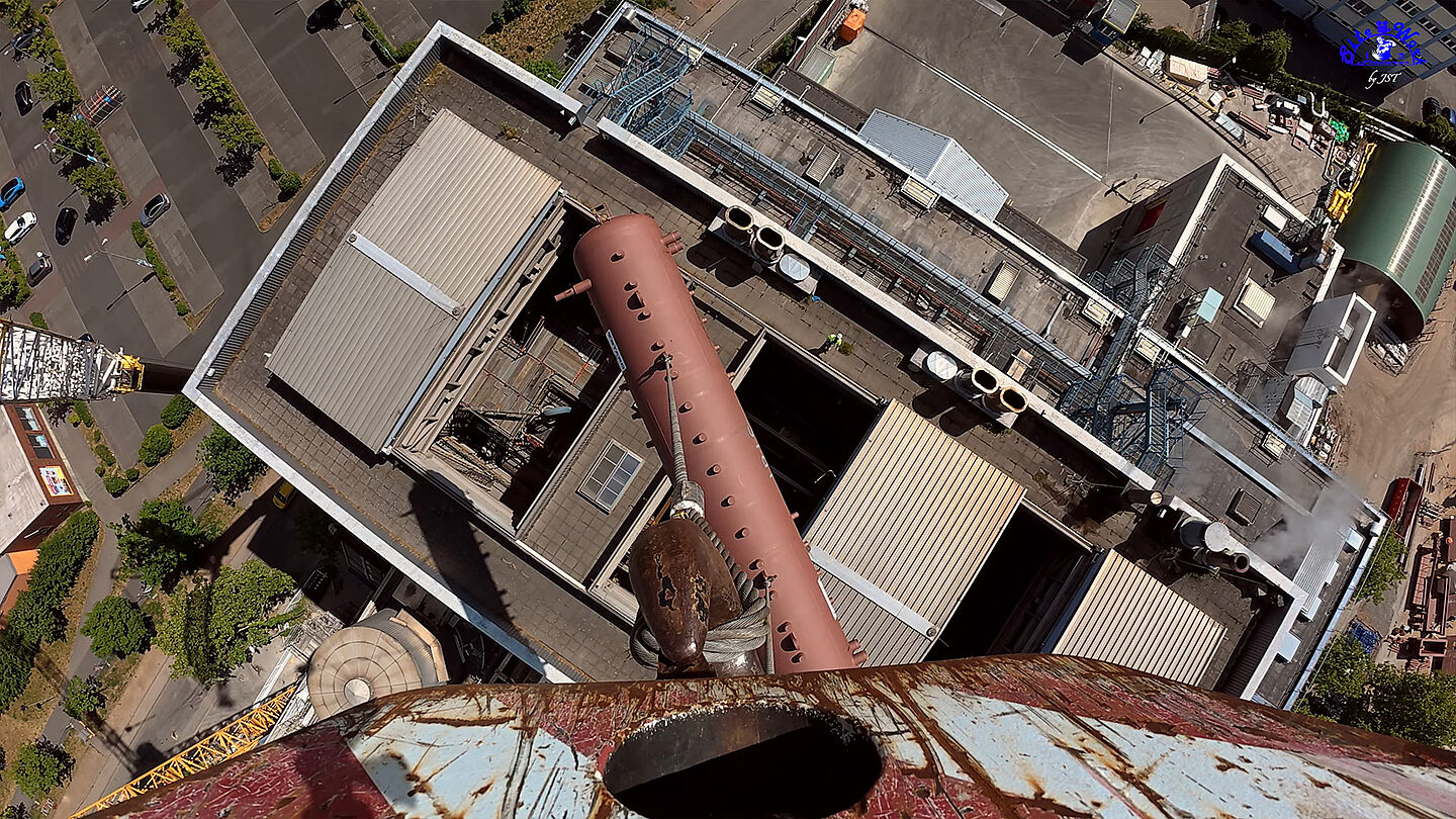 Industrieanlage mit Schornsteinen und Rohrleitungen aus Vogelperspektive.