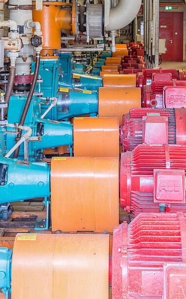 Industrielle Anlage mit Rohren, Ventilen und Maschinen zur Prozesssteuerung.