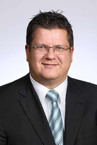 Porträt eines Mannes im Anzug mit Krawatte, professionelles Erscheinungsbild.